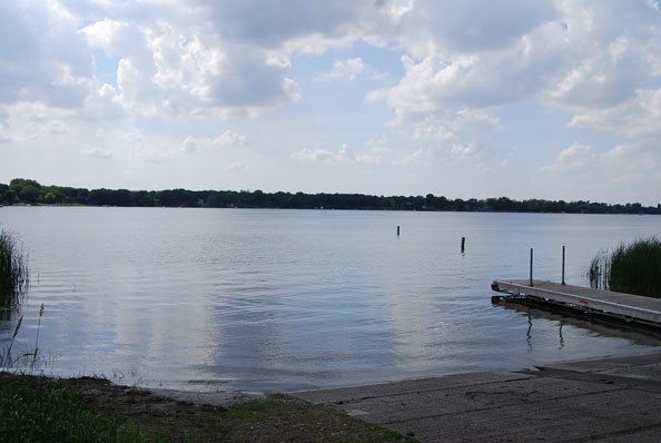 A lake viewed from the boat launch. A dock is on the right side. 