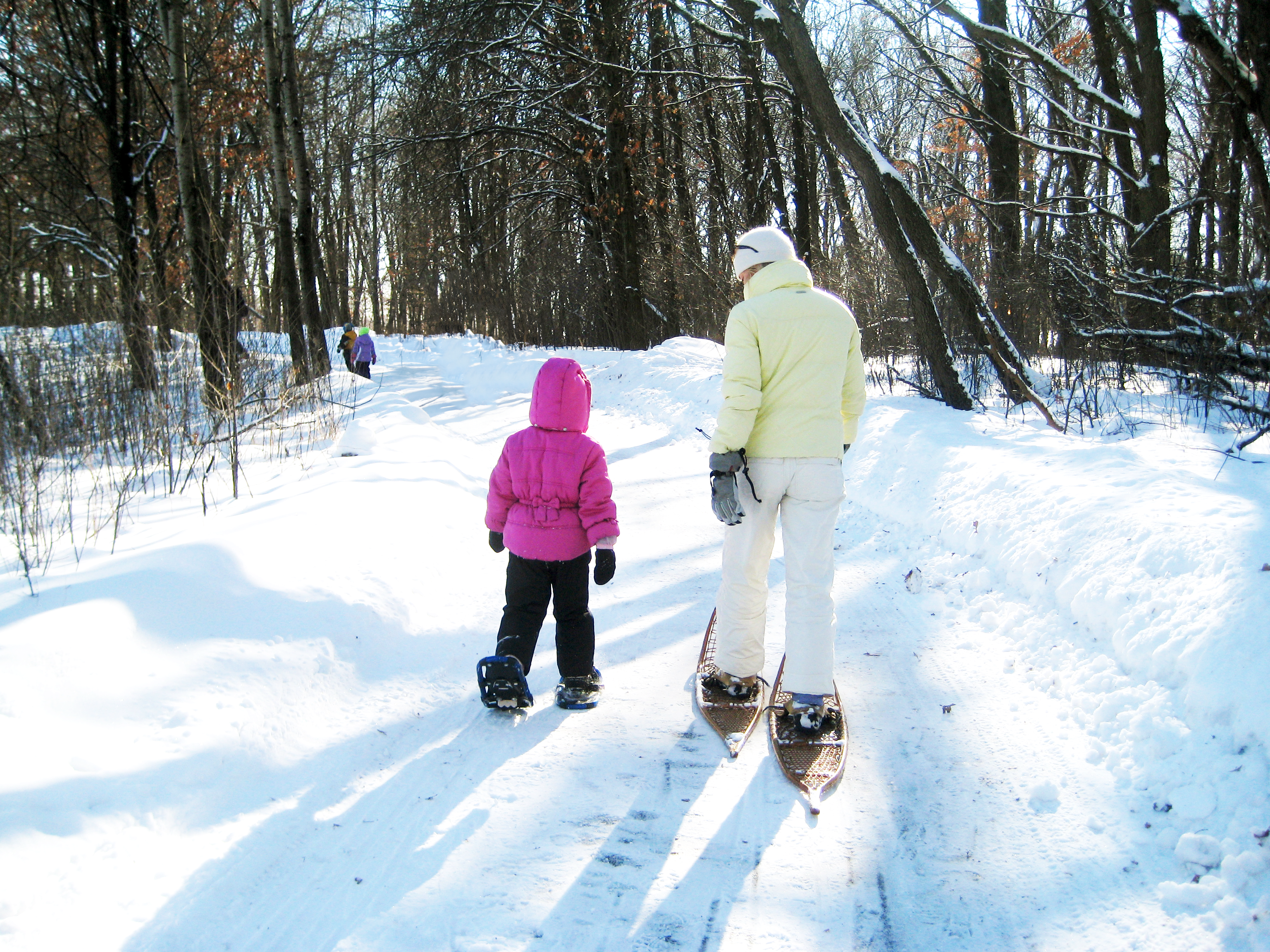 Mother and daughter walking in snowshoes on show trail